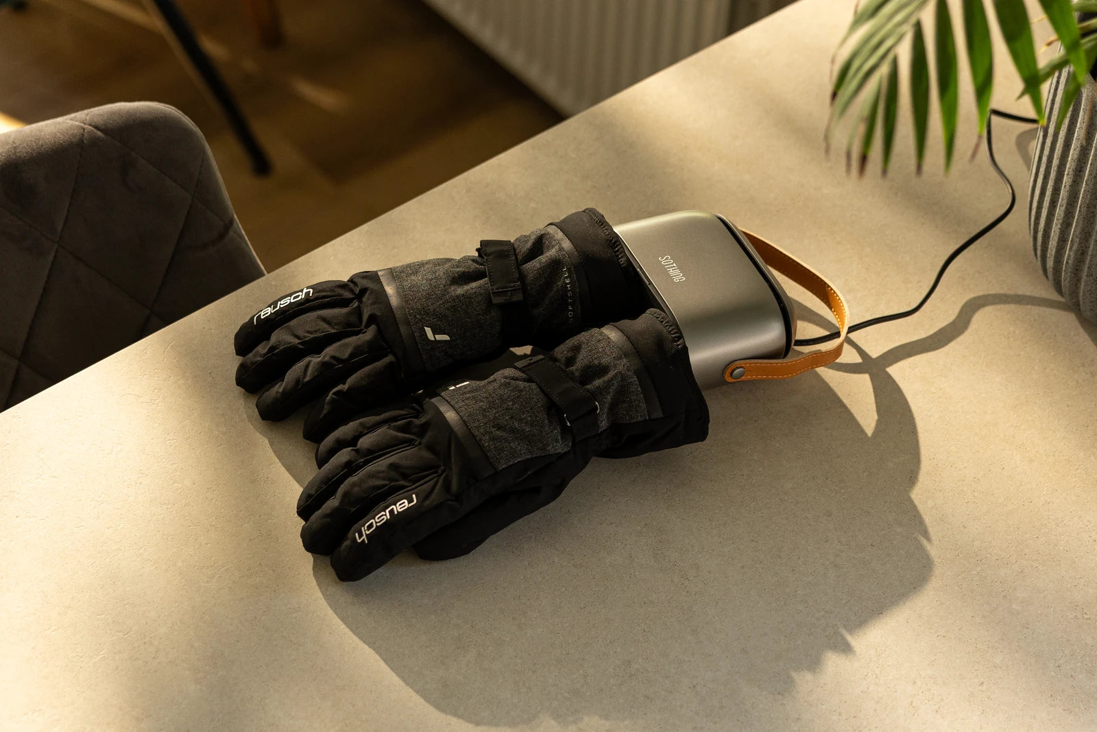 Original Ultra Grey and Reusch gloves photographed on a sunlit table, with the original rear power cord